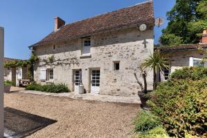 an old stone house with a palm tree in front of it at La Fromagerie in Mondion