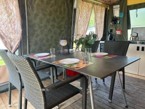 a table in a kitchen with chairs and a tableablish at Camping De Meidoorn in Sluis