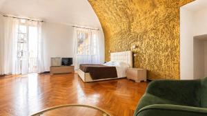 a bedroom with a bed and a couch and a tv at Hotel Terme Neronensis in Pozzuoli