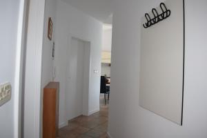 a hallway with white walls and a door with a sign at Apartment Mali Mol in Vantačići