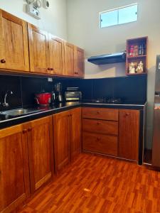 a kitchen with wooden cabinets and a wooden floor at La Casita de Kevin in Los Órganos
