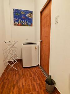 a small refrigerator in a room with a wooden door at La Casita de Kevin in Los Órganos +1 photo