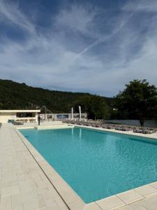 a large blue swimming pool with chairs and trees at Vega House Luxury & Relax in Orşova