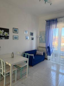 a living room with a blue couch and a table at A un passo dal mare! in Piombino