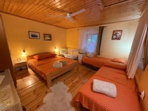 a bedroom with two beds and a wooden ceiling at Ethno House Ivanovic in Virpazar
