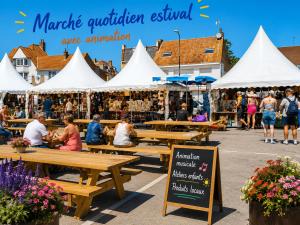a market with wooden tables and white tents at Appartement Imalia Prestige et Elegance in Bray-Dunes