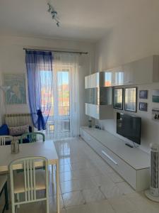 a living room with a table and a tv in it at A un passo dal mare! in Piombino