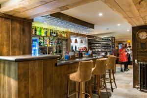 a bar in a pub with stools and a clock at Barley Mow in Burnley