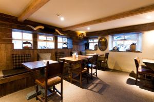 a restaurant with wooden tables and chairs and windows at Barley Mow in Burnley