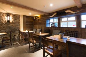 a restaurant with wooden tables and chairs and windows at Barley Mow in Burnley +17 photos