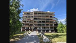 a tall apartment building with a path in front of it at Studio rez de jardin Praloup in Uvernet