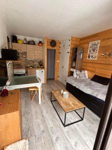 a room with a bed and a desk in it at Studio rez de jardin Praloup in Uvernet