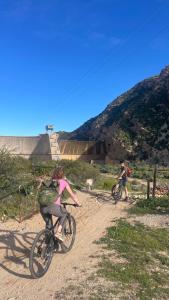 two people riding bikes on a dirt road at Doornkraal Farm in De Rust
