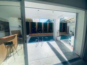 a view of a swimming pool through a sliding glass door at Villa haut-standing avec piscine à Hammamet in Yasmine