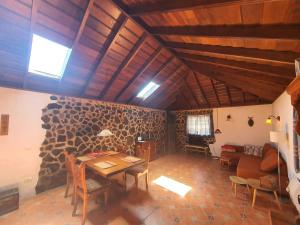 a living room with a table and a stone wall at Casa Glorieta in Los Llanos de Aridane
