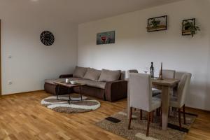 a living room with a couch and a table at New Modern Apartments with Private Parking in Leštane