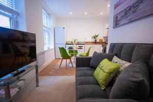 a living room with a couch and a television at Derby Luxury Apartments - Curzon in Derby