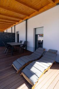 a row of pillows on a deck with a table at Vila Trta in Moravske-Toplice
