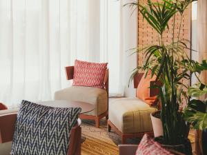 a living room with a chair and a plant at Hotel Mediterráneo in Roses