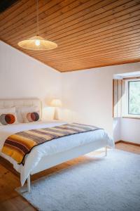 a bedroom with a bed with a wooden ceiling at Serra Casa in Marvão