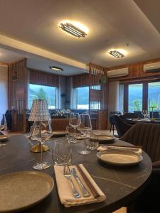 a dining room with a table with wine glasses on it at Chalet les moineaux Appartements in Jausiers