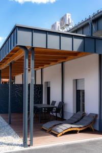 a house with a deck with a table and chairs at Vila Trta in Moravske-Toplice