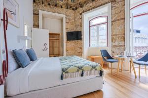 a bedroom with a bed and a table and chairs at Casa da Portagem by PURUS in Coimbra