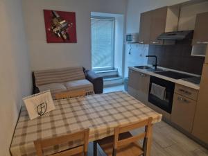 a kitchen and living room with a table and a couch at Josef apartment, CENTER in Solkan