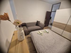 a living room with a couch and a table with a vase at Josef apartment, CENTER in Solkan