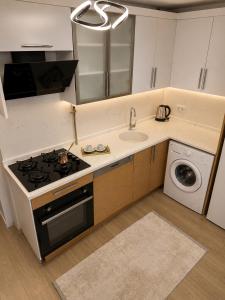a kitchen with a stove top oven next to a sink at Airport Suite Trabzon in Trabzon