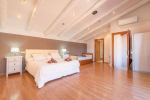 a large bedroom with a white bed and wooden floors at Cal Ferrer Nou Costa Brava in Riumors
