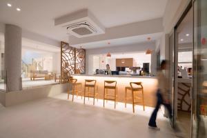 a man walking past a kitchen with bar stools at Horizon Beach in Stalís +109 photos