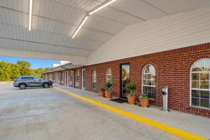 a car parked in front of a brick building at Stay Inn Checotah near Eufaula Lake in Checotah +17 photos