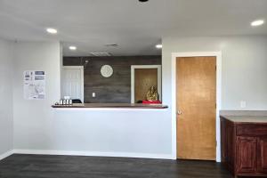 a room with a white wall and a wooden door at Stay Inn Checotah near Eufaula Lake in Checotah