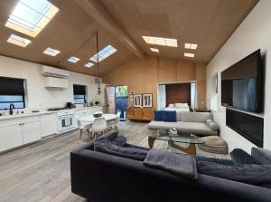 a large living room with a couch and a kitchen at Private Venice Beach Luxury Bungalow, Outdoor Tub, Steps To Ocean & Abbot Kinney in Los Angeles