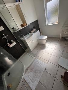 a bathroom with a tub and a toilet and a sink at Cosy double room close to coastal path routes in Barnstaple