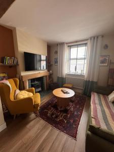 a living room with a couch and a table at Cosy double room close to coastal path routes in Barnstaple