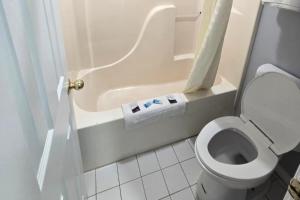 a bathroom with a toilet and a bath tub at Stay Inn Checotah near Eufaula Lake in Checotah