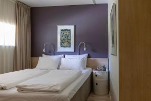 a bedroom with a large bed with a purple wall at Sørmarka Konferansehotell in Siggerud