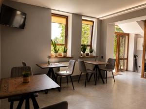 a dining room with tables and chairs and windows at Villa Caza in Chişinău