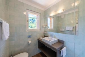 a white bathroom with a sink and a window at Hotel Hanny Panoramic Views over Bolzano in Bolzano +87 photos