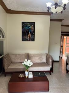a living room with a couch and a table at Happy Fish Villa in Entebbe