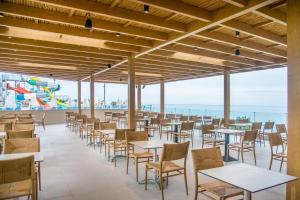 a restaurant with tables and chairs and the ocean in the background at Horizon Beach in Stalís