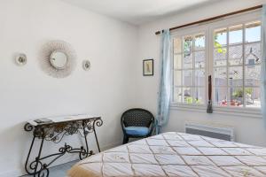 a bedroom with a bed and a desk and a window at La Fromagerie in Mondion +23 photos