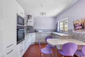 a kitchen with purple chairs and a table at La Fromagerie in Mondion