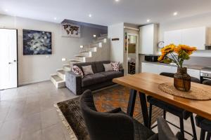 a living room with a table and a couch at Cavour Living – Luxury Design Olbia Centro in Olbia +19 photos