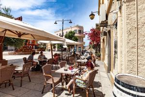 a group of people sitting at tables at an outdoor restaurant at Cavour Living – Luxury Design Olbia Centro in Olbia