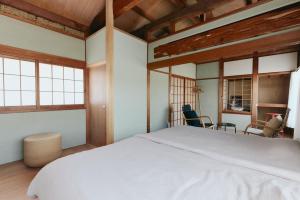 a bedroom with a white bed and two windows at kawasakike in Takamatsu