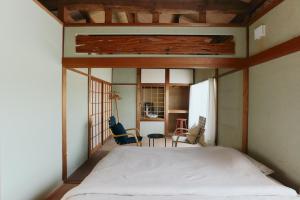 a bedroom with a bed and chairs in it at kawasakike in Takamatsu