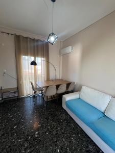ein Zimmer mit einem Bett, einem Tisch und einer Couch in der Unterkunft Light Apartment in Ierápetra
